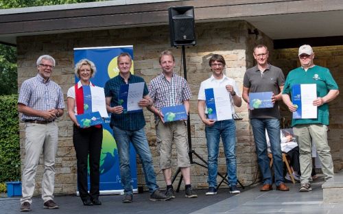 Hubert Hoffmann (links) überreicht Urkunden und Schilder an den Arbeitskreis 